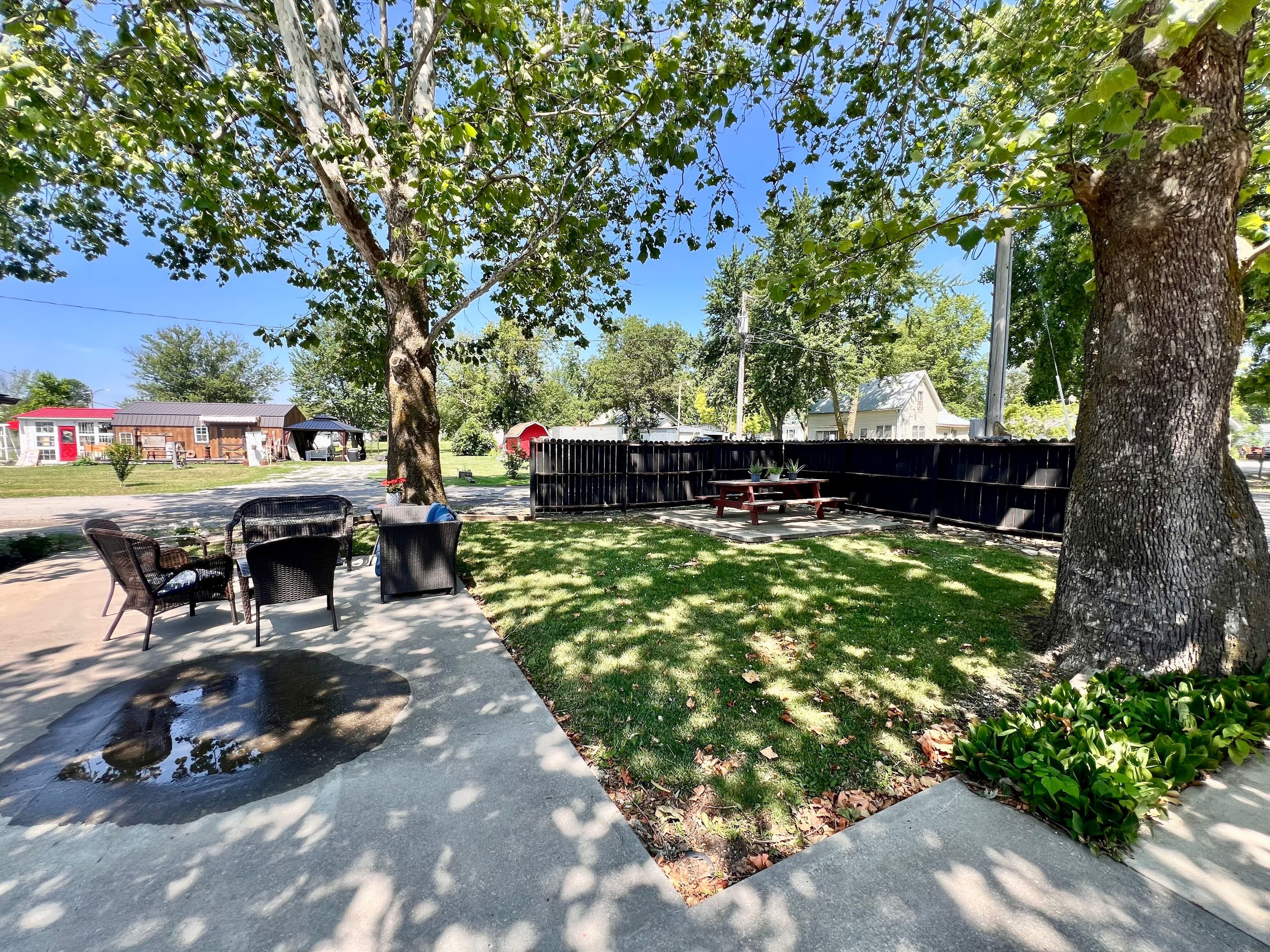 Outdoor setting area next to fire pit and mature trees