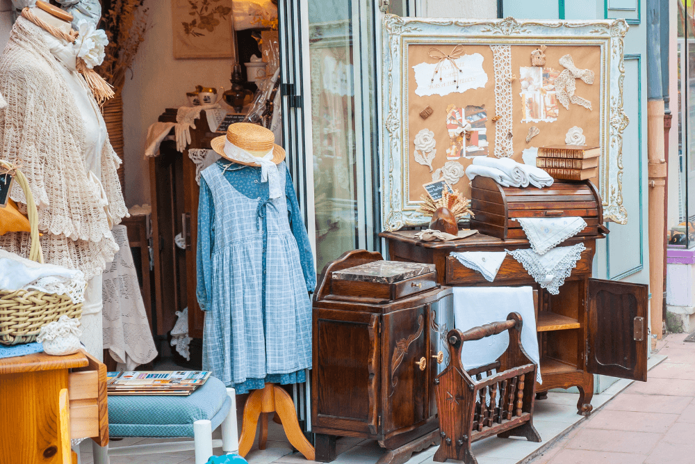 Shop entrance on street with amish clothes and furniture on display outside the entry way.